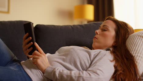 Close-Up-Of-Woman-Lying-On-Sofa-At-Home-At-Streaming-Or-Watching-Movie-Or-Show-Or-Scrolling-Internet-On-Mobile-Phone-5